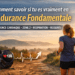 Femme d’une quarantaine d’années courant en endurance fondamentale sur un chemin au lever du jour, avec une montre cardio illustrant la zone 2 et la fréquence cardiaque.